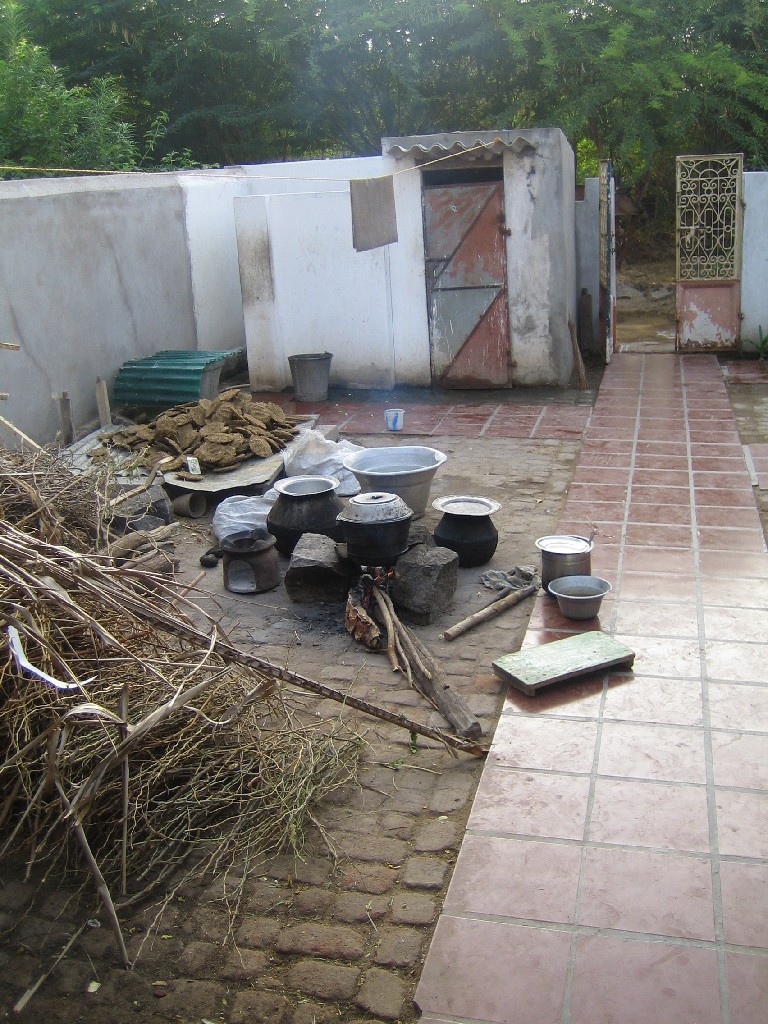 IMG_2774 Other side of courtyard shows:
- wood to cook
- outside fireplace
- dried cow dung to be burned
- in the back the shower and the toilet 